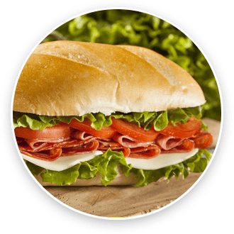 A sandwich with salami, cheese, and lettuce in a white roll on a green background.