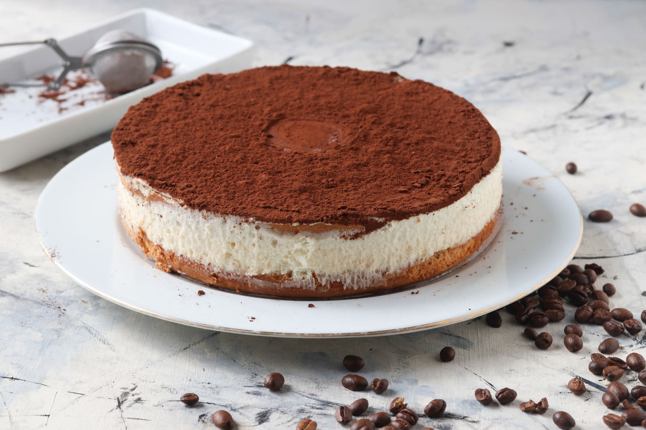 Round tiramisu cake dusted with cocoa powder