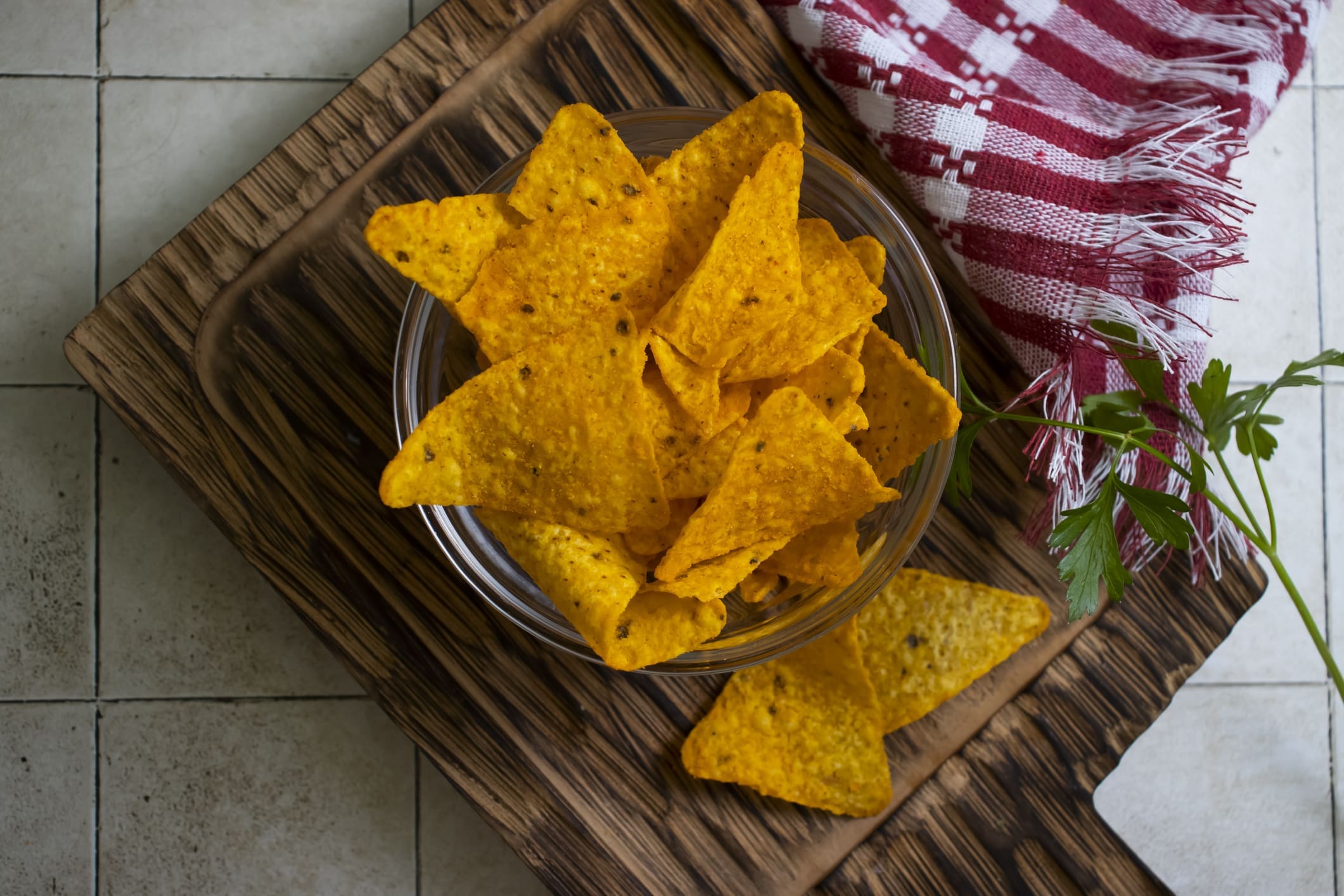 Bowl of yellow tortilla chips on cutting board