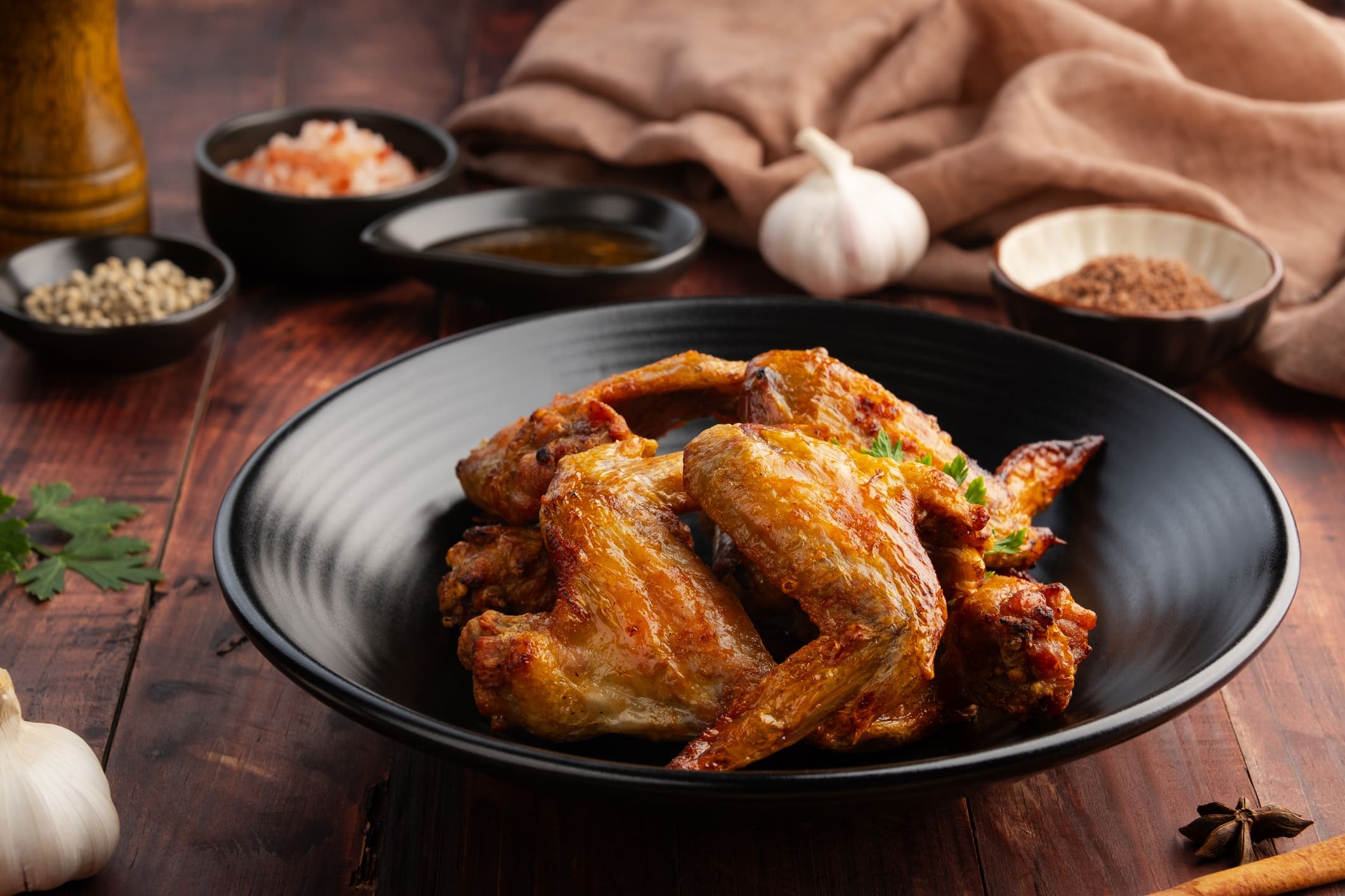 Crispy roasted chicken wings on black plate