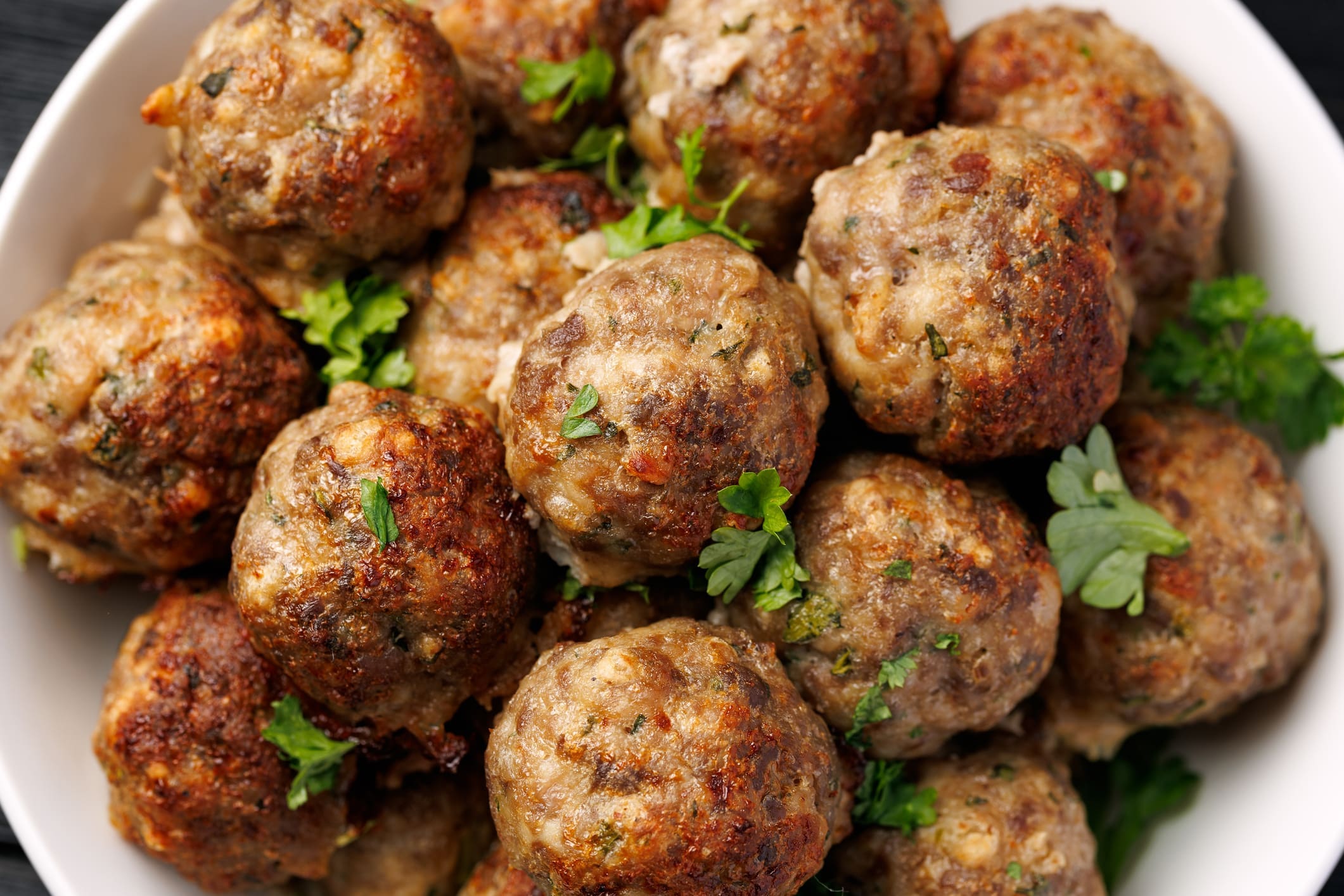 Bowl of seasoned beef meatballs with parsley